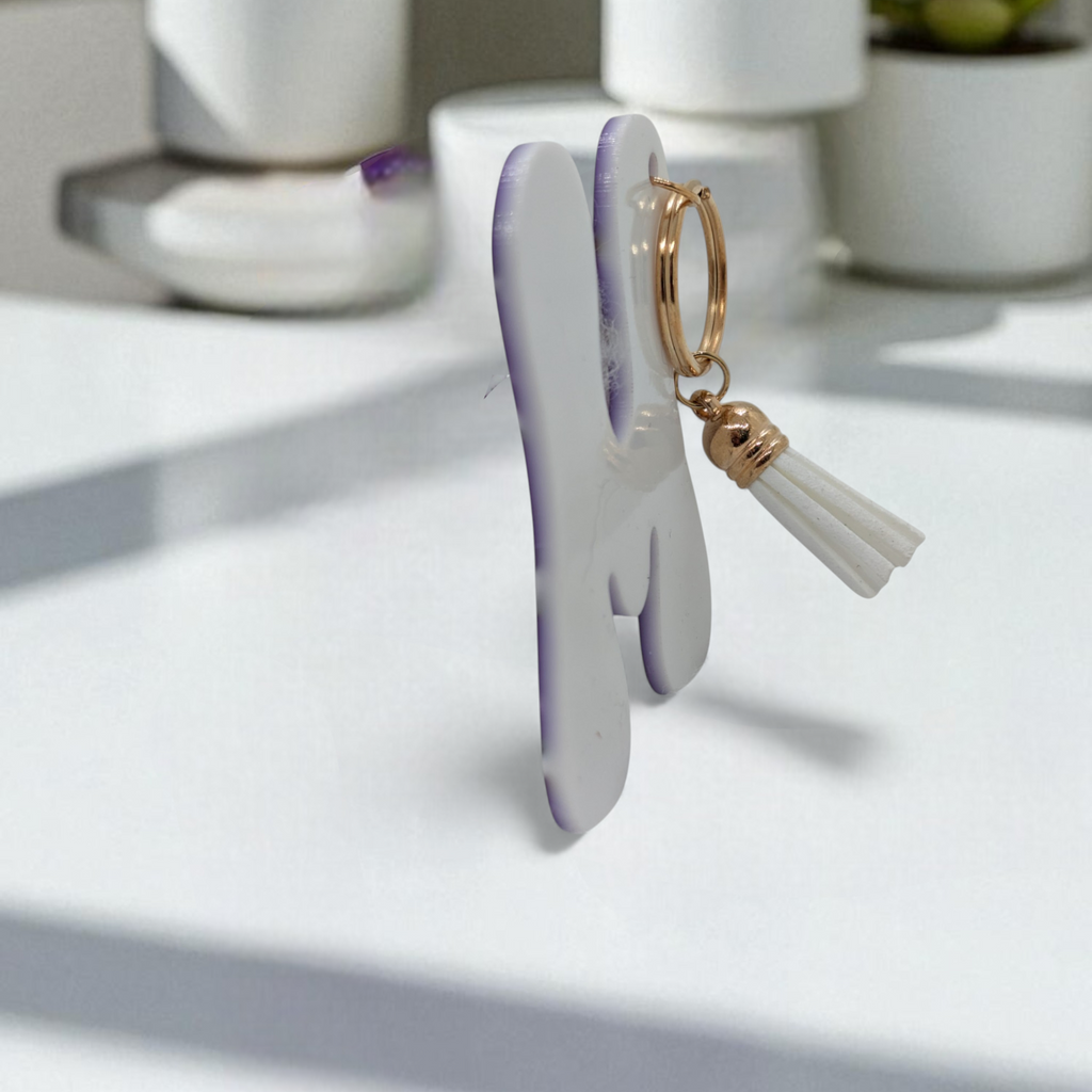 white back of acrylic keychain in the shape of a letter M