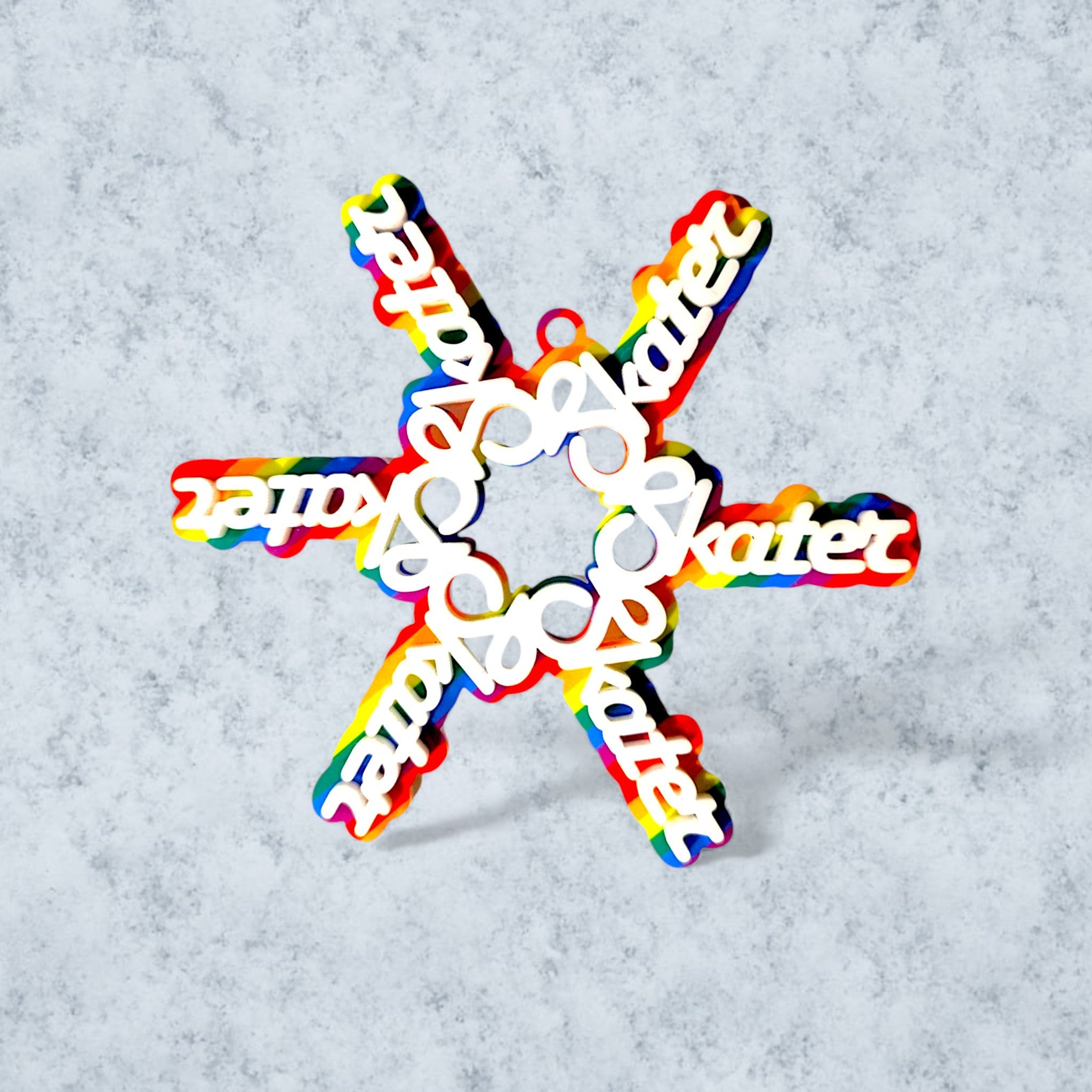 colorful snowflake ornament made of the word 'skater' in white on a rainbow background